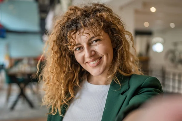 Kafkasyalı Mutlu Bir Kadın Kafenin Içinde Kıvırcık Saçlı Bir Gülümsemeyle — Stok fotoğraf