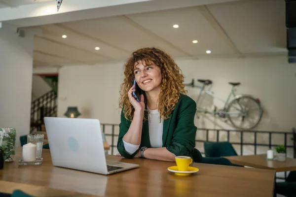1人の女性大人Caucasian女性座ってカフェワークでノートパソコン電話話幸せな笑顔自信を持って笑顔本物の人のコピースペース — ストック写真
