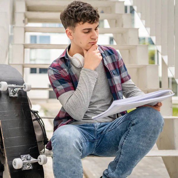 1人の若い男ティーンCaucasian学生とともに本を読みます研究でキャンパスで一日に座って階段教育の概念コピースペース — ストック写真