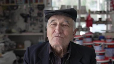 Kafkasyalı yaşlı bir adamın portresi. Büyükbaba içeride oturuyor. Şapka takıyor ve kameraya bakıyor.