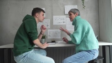 One student teenage caucasian man study learn with help of his tutor professor or mother senior woman at home having private lesson to prepare for exam education concept real people