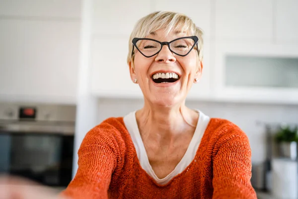 一位长发女士的近照笑容满面积极情绪抄袭空间站在厨房室内戴眼镜自画像用户产生的内容 — 图库照片