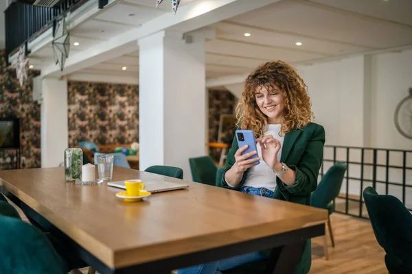 1人の女性大人白人女性はカフェで座っているオンラインインターネットの閲覧やSmsテキストメッセージのための携帯電話を使用して幸せな笑顔自信を持って笑顔本物の人コピースペース — ストック写真