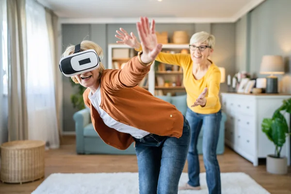 两个成熟的女性老年白种人的朋友或姐妹在家里享受虚拟现实Vr耳机真正的人积极的老年人有乐趣的休闲概念 — 图库照片