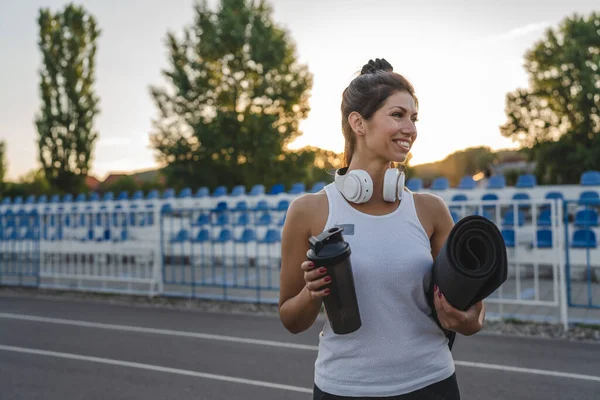 코카서스 선수는 저녁에 훈련을 헤드폰을 부속품 샤커와 매트를 가지고 경기장에서 — 스톡 사진