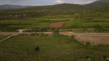 Güneşli bir günde asfalt bir yolun manzaralı güzelliği İHA 'nın perspektifinden geçen arabaların asfalt hava aracının Sırbistan' daki bakış açısıyla sürüşü.