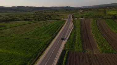 Güneşli bir günde asfalt bir yolun manzaralı güzelliği İHA 'nın perspektifinden geçen arabaların asfalt hava aracının Sırbistan' daki bakış açısıyla sürüşü.