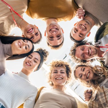 Bir grup beyaz erkek ve kadın iş kıyafeti giymiş kadın ve erkek bir araya toplanmış destek ve işbirliği içinde bir proje için beyin fırtınası ya da strateji oluşturuyorlar.