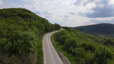 Otomobili otomobille gezerken hava aracı görüntüsü ilkbahar günü dağlık alanda ağaçların arasından geçerek - Sırbistan 'da Tresibaba Knjazevac - Seyahat yolculuğu ve tatil konsept araba sürüşü