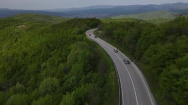 Otomobili otomobille gezerken hava aracı görüntüsü ilkbahar günü dağlık alanda ağaçların arasından geçerek - Sırbistan 'da Tresibaba Knjazevac - Seyahat yolculuğu ve tatil konsept araba sürüşü