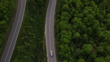 Sırbistan 'da yeşil ve manzara taşımacılığı ve seyahat konseptiyle çevrili dolambaçlı yol boyunca giden bahar aracı otomobili sırasında, bir dağ sırasındaki eğimli asfalt bir yolun hava aracı görüntüleri