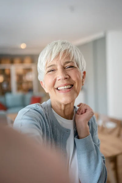 stock image Close up portrait of one senior woman with short hair happy smile positive emotion copy space standing at home indoor gray white hair self portrait selfie user generated content ugc