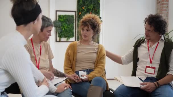 一群人围坐在一起 由两名治疗师和一名妇女组成 讨论并为她提供感情上的支持 重点是这个女人 但每个人都在谈话 — 图库视频影像