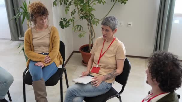 Группа Людей Сидящих Кругу Двумя Терапевтами Женщиной Центре Обсуждающих Оказывающих — стоковое видео