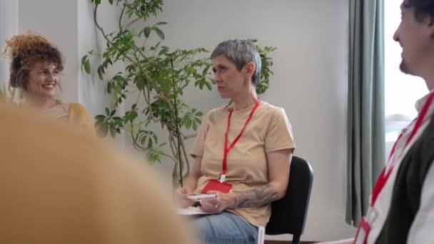 Группа Людей Сидящих Кругу Двумя Терапевтами Женщиной Центре Обсуждающих Оказывающих — стоковое видео