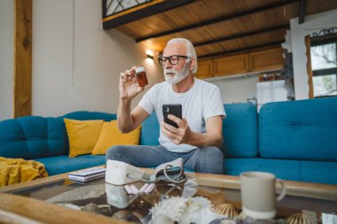 Son sınıflardan biri elinde ilaç ya da takviye ilaç şişesiyle kanepede oturuyor. Akıllı telefon, ilaç tableti, ağrı kesici ya da ilaç almaya hazır vitamin talimatları okuyor.