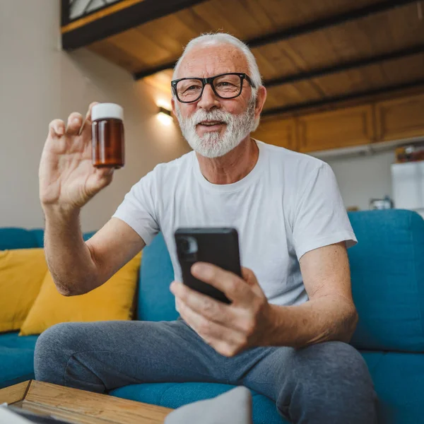 Son sınıflardan biri elinde ilaç ya da takviye ilaç şişesiyle kanepede oturuyor. Akıllı telefon, ilaç tableti, ağrı kesici ya da ilaç almaya hazır vitamin talimatları okuyor.