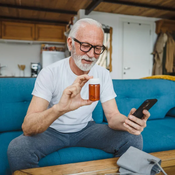 Son sınıflardan biri elinde ilaç ya da takviye ilaç şişesiyle kanepede oturuyor. Akıllı telefon, ilaç tableti, ağrı kesici ya da ilaç almaya hazır vitamin talimatları okuyor.