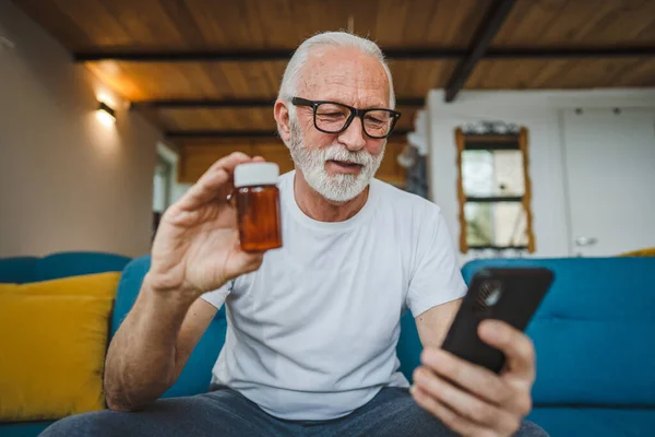Egy Idős Férfi Otthon Kanapén Egy Üveg Gyógyszerrel Kezében Gyógyszer — Stock Fotó