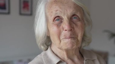 Yaşlı, yaşlı bir kadın Kafkas emeklisi evde tek başına dikiliyor. Yakın plan portresi. Bunama, Alzheimer hastalığı ve depresyon konseptine bakın. 