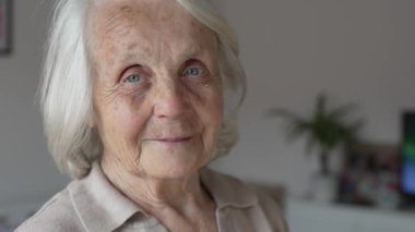 Yaşlı, yaşlı bir kadın Kafkas emeklisi evde tek başına dikiliyor. Yakın plan portresi. Bunama, Alzheimer hastalığı ve depresyon konseptine bakın. 