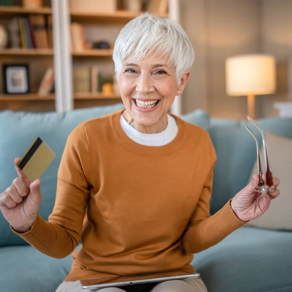 stock image One mature senior woman grandmother sit at home use credit or debit card for online shopping browse internet stores buying stuff on discount sale real people copy space use digital tablet