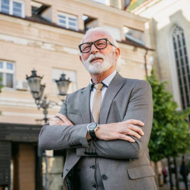 Takım elbiseli kıdemli işadamının portresi dışarıda duruyor.