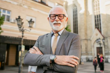 Takım elbiseli kıdemli işadamının portresi dışarıda duruyor.