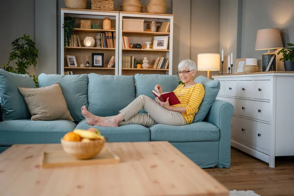 一人の女性成熟したシニアCaucasian女性年金現代祖母読みます本で家庭用眼鏡本物の人コピースペース — ストック写真