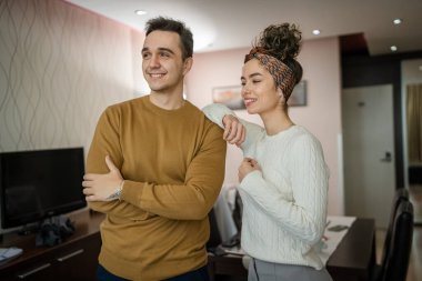 Happy couple woman and man caucasian husband and wife or girlfriend and boyfriend standing at home happy smile in their apartment real people copy space