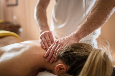 Kimliği belirsiz bir kadın, güzellik merkezinde erkek beyaz bir terapistin yaptığı boyun masajı sırasında yalan söylüyor. Sağlık hizmetleri rahatlama konsepti fotokopi alanı.