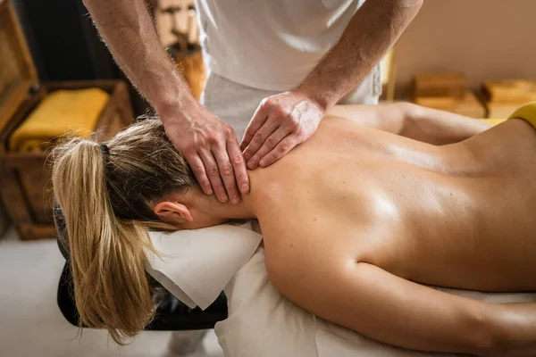 Unknown woman lying while have neck massage by male caucasian therapist at beauty spa treatments salon healthcare relaxation concept copy space