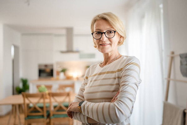 Портрет одной зрелой белокурой белокурой женщины в очках дома счастливая улыбка глядя в камеру уверенно носить свитер в яркой комнате копировать пространство
