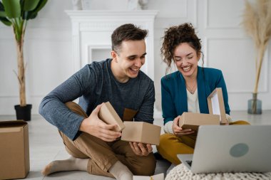Genç çift erkek ve kadın erkek ve kız arkadaş ya da karı koca hediyelerini evde değiştirip birbirlerine hediye veriyorlar ve mutlu bir gülümseme açıyorlar sevgililer günü bayramı ya da doğum günü kutluyorlar.