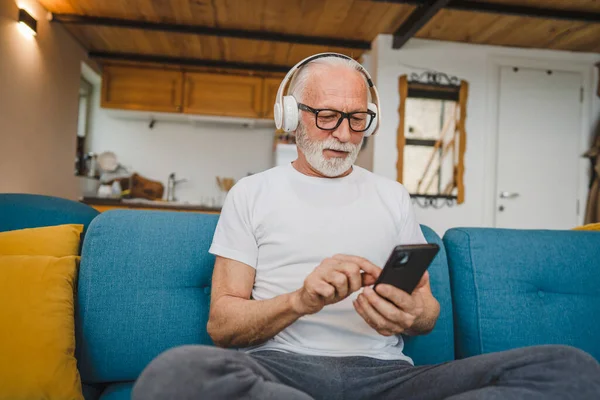 Ein Älterer Mann Mit Kopfhörern Benutzt Smsrtphone Hause Musik Machen — Stockfoto