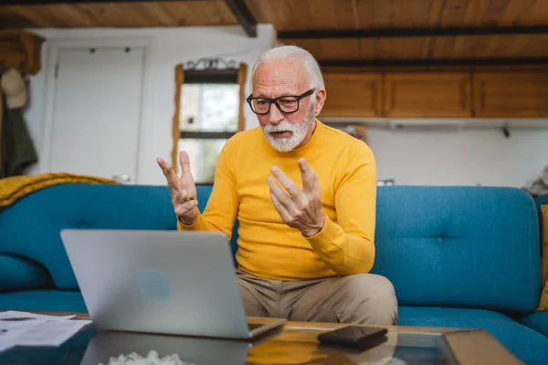 stock image One senior caucasian man grandfather with beard and eyeglasses work on laptop use computer at home online video call