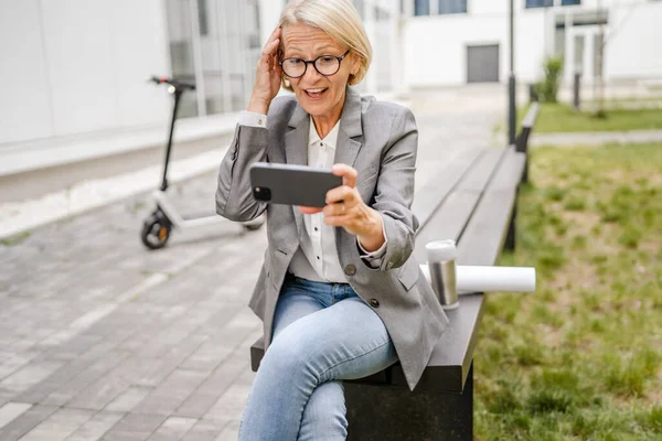 One Mature Blonde Caucasian Woman Sit Outdoor Happy Smile Play — Stock Photo, Image