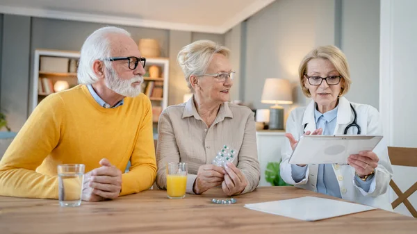Mature woman doctor visit senior couple man and female husband and wife having a talk and consulting about diagnosis and medical medication treatment real people healthcare concept copy space