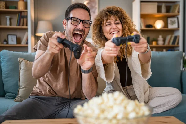 stock image Adult couple man and woman caucasian husband and wife or boyfriend and girlfriend play console video games at home hold joystick controller have fun leisure joy and bonding concept copy space
