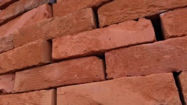 Depodaki palette bir yığın kırmızı kil tuğla var. Yaklaş.
