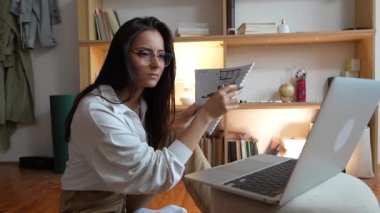 Genç beyaz kadın evde dizüstü bilgisayarın önünde ders çalışıyor - kadın kitap hazırlama sınavı ya da ödev sınavı online danışmanlık - eğitim ve öğrenme konsepti yavaş çekim