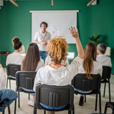 Koç eğitimi seminerdeki bir grup çalışana soruyu açıklar.