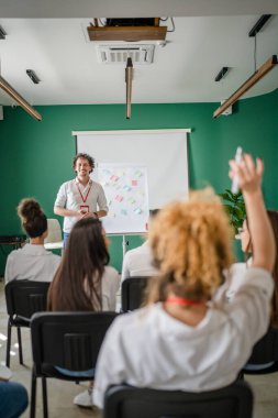 Koç eğitimi seminerdeki bir grup çalışana soruyu açıklar.
