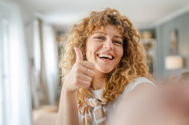 Yetişkin beyaz bir kadının portresi. Mutlu, kıvırcık saçlı.