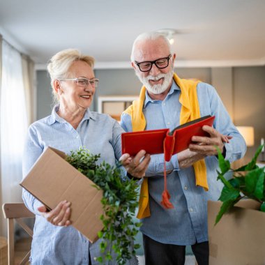Üst düzey karı koca aile fotoğraflarına bakıyor. Kafkasyalı yaşlı erkek ve kadın büyükbaba ve büyükanne mutlu bir gülümseme. Evde eski resimlerle gerçek insanlar uzay kopyaları yapıyor.