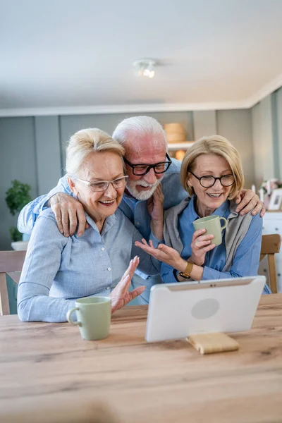成熟した高齢者のグループ白人の家族や友人は自宅でのビデオ通話のためのデジタルタブレットを使用してスペースをコピーします — ストック写真
