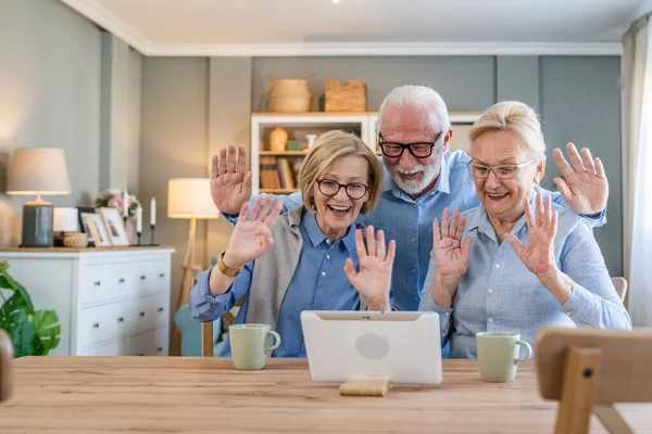 成熟した高齢者のグループ白人の家族や友人は自宅でのビデオ通話のためのデジタルタブレットを使用してスペースをコピーします — ストック写真