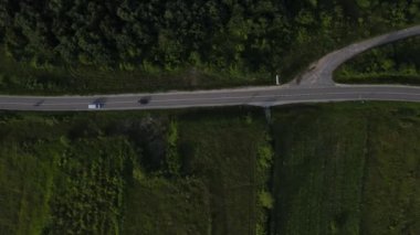 Sırbistan 'da yeşillik ve manzara taşımacılığı ve seyahat konseptiyle çevrili dolambaçlı yol boyunca giden yaz aracı otomobili sırasında bir dağ sırasındaki eğimli asfalt bir yolun hava aracı görüntüleri