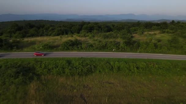 在塞尔维亚 夏季汽车沿着蜿蜒的道路行驶时 在山脉上一条弯曲的沥青路面的空中无人驾驶镜头 周围环绕着绿地 交通和旅行的概念 — 图库视频影像