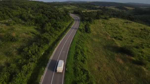 在塞尔维亚 夏季汽车面包车沿着蜿蜒的道路行驶 周围环绕着绿树成荫的风景 交通和旅行的概念 — 图库视频影像
